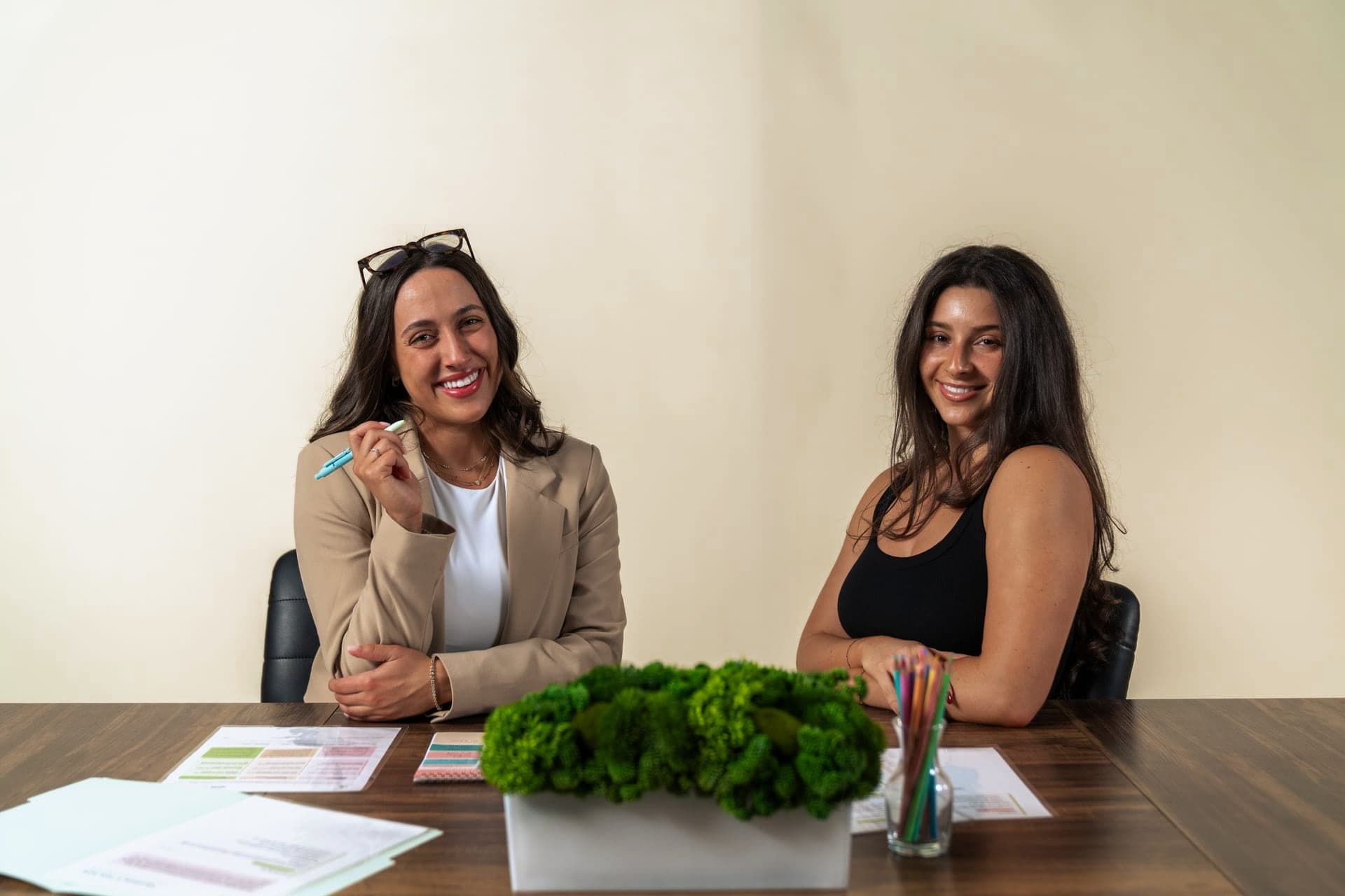 Two Just Start LA coaches at a working table with planning materials